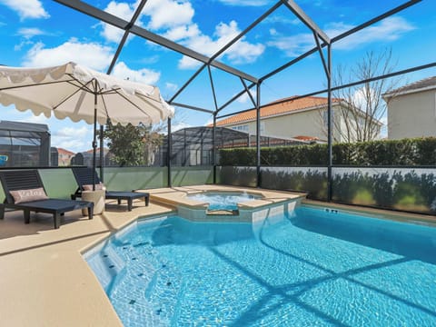 Screened outdoor pool area w/ spa & loungers under sunny skies