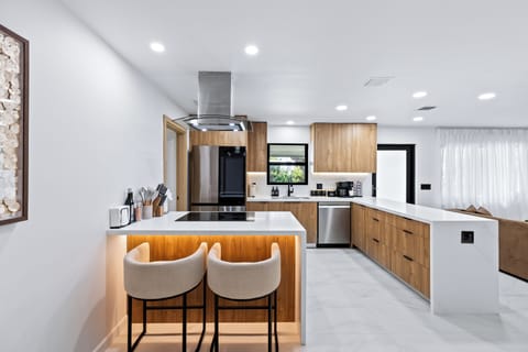 Modern kitchen with bar seating and sleek finishes for easy meals at home.