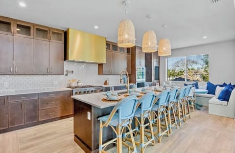 Your dream kitchen awaits with a spacious island, sleek appliances, and coastal-inspired seating where morning coffee feels like a retreat.