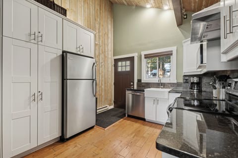 Your fully equipped kitchen features granite counters, stainless appliances, and warm wood accents for cooking memorable meals.