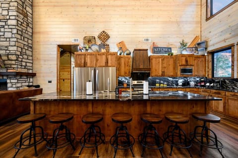 This gorgeous log cabin kitchen has an island that seats seven and flows into the open living space with those amazing views.