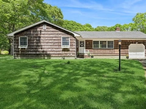 Classic cedar-shingle ranch with manicured lawn in Hampton Bays