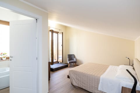 Bright double bedroom in accommodation located in Verona, featuring cozy spaces and direct access to the outside. Furnished in a modern and functional style, the room has a double bed, dedicated lighting, and a relaxation area, ideal for a comfortable and independent stay.