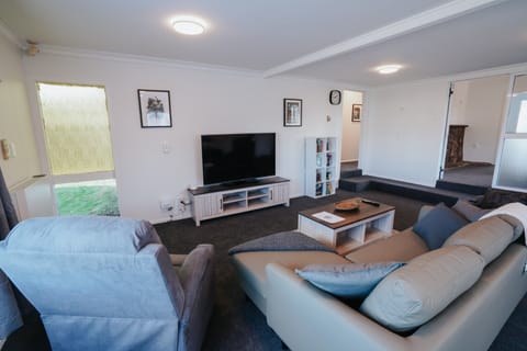 Spacious and bright living room with comfortable seating, modern furnishings, and large windows letting in natural light. Perfect for relaxing or spending quality time with family and friends.