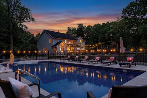 Magical sunset swims with a glowing pool, string lights, and comfy loungers!