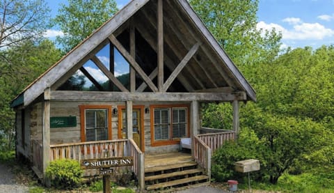 Charming A-frame studio cabin with covered front porch nestled in the trees at Adorable Shut'er Inn in Pigeon Forge, Tennessee — just minutes from the Pigeon Forge Parkway and Dollywood.