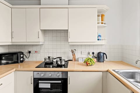 Bright, fully equipped kitchen with ample storage and warm wood countertops