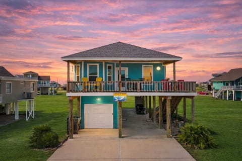 Beach-view Galveston vacation home with elevated coastal design, large driveway parking, and easy access to the beach just across the street.
