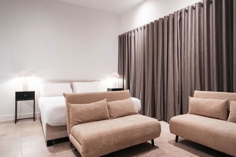 Relax in a plush king bed with a cozy seating area—perfect for unwinding after a day out.