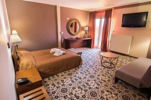 Spacious suite bedroom with warm lighting and comfortable seating area