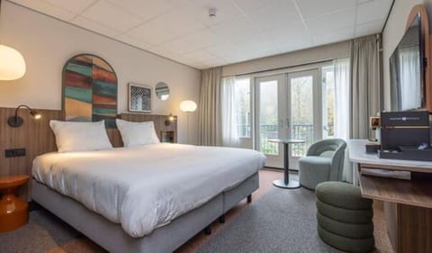 Unwind in a bright king bed with balcony doors open.