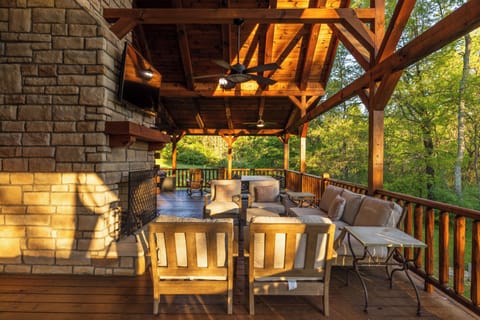 Soft seating and an outdoor fireplace provide a quiet space to enjoy the wooded surroundings or watch Football on the big screen TV.