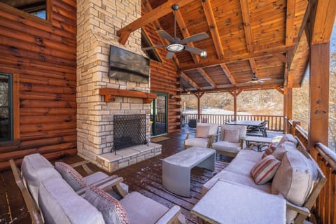 Soft seating and an outdoor fireplace provide a quiet space to enjoy the wooded surroundings.