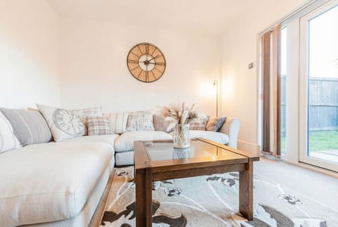 Sink into the plush corner sofa and let the garden light wash over a beautifully styled living room.