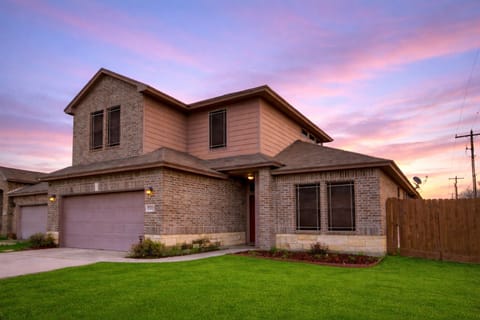 Stunning two-story brick home with a spacious garage and sunset views.