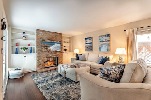 Sink into the plush sectional sofa and cozy up by the exposed brick fireplace — this warm, beautifully decorated living room is perfect for relaxing evenings with great company.