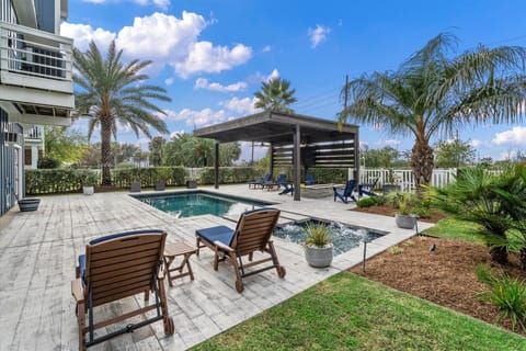 Private resort-style pool with tanning ledge, luxury lounge chairs, and tropical landscaping creating a relaxing outdoor retreat.