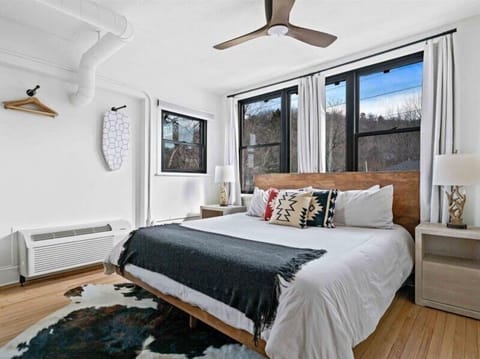 Enjoy a spacious, stylish bedroom in Asheville featuring a king bed, contemporary décor, and abundant natural light.