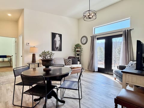 Bright and cozy living space with large doors opening to peaceful countryside views.