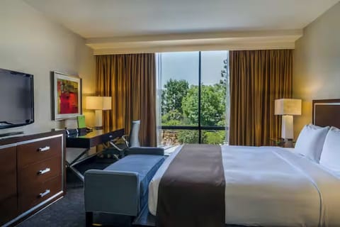 Unwind in crisp linens beside a sunlit picture window.