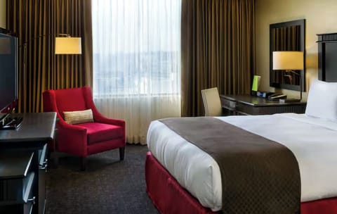 Unwind in a plush bed beside a cozy reading chair.