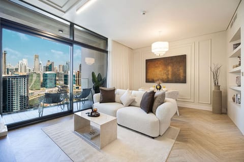 Bright, stylish living room with stunning skyline and canal views — your perfect Dubai retreat