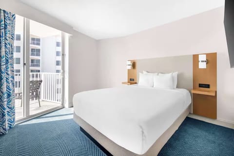 Unwind in a sunlit king bed steps from balcony breezes.