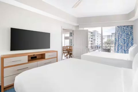 Recharge in a calm bedroom with TV and clean lines.