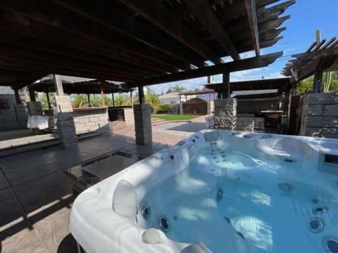 Jacuzzi set within a gorgeous and spacious backyard with outdoor kitchen and bar, great for entertainment.