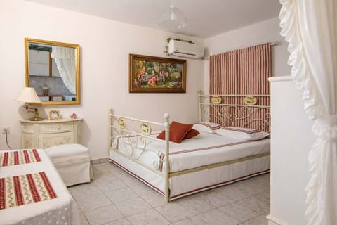 Bright and inviting bedroom featuring a charming iron bed, soft linens, and elegant décor. The space offers a warm and relaxing atmosphere, making it perfect for unwinding after a day exploring 