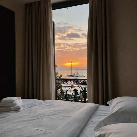 Bedroom with Sea View Framed by Curtains at Sunset