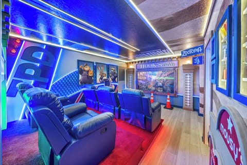 Experience a vibrant entertainment room with plush leather recliners and lively blue lighting that creates an energetic atmosphere.