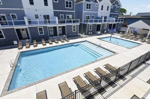 Views of the shared pool, splash pad and 4 community gas grills, TV and benches.