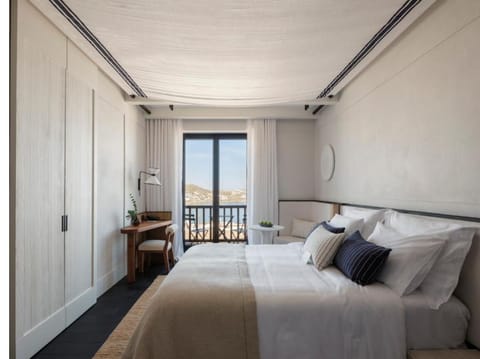 Unwind in crisp linens with balcony views beyond.