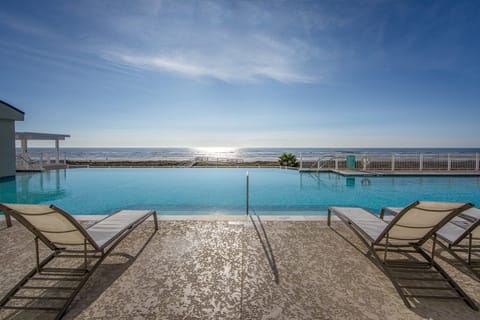 Take a refreshing dip in the infinity pool as the sun dances on the ocean waves.