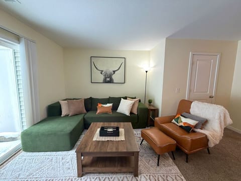 Green sectional and leather chair ready for movie nights and wine chats