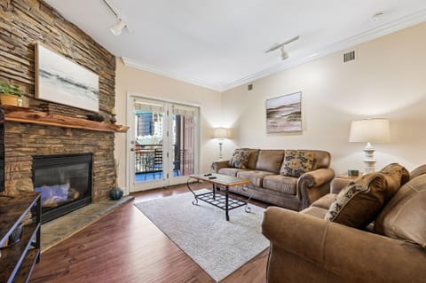 Sink into plush leather sofas by your stone fireplace, where warm evenings unfold naturally in this inviting living space.