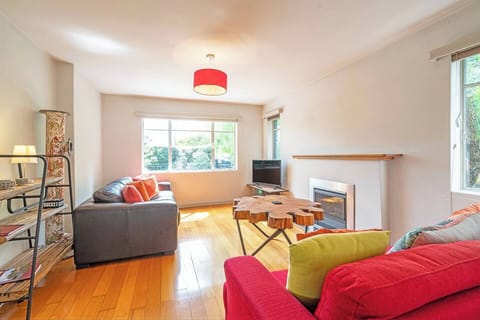 This bright and welcoming living space features cosy seating, vibrant touches and plenty of natural light. Note that the fireplace is not functional. 