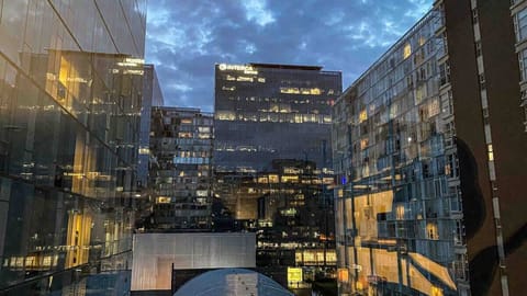 Esta  imagen captura la vista desde la sala de estar. Todas las habitaciones comparten este mismo escenario vibrante de la ciudad. 