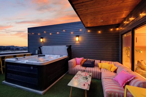 Rooftop hot tub with skyline views, string lights, and sunset vibes. (Girls Night Out)
