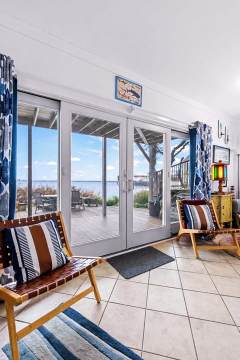 Sunlit waterfront lounge with deck access and sweeping bay views.
