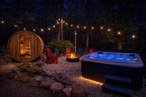 Slide into the hot tub after dark — the sauna glowing beside you, the fire crackling across the gravel, string lights overhead. You can't agree on which to do first.