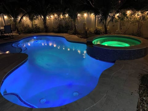 Private backyard retreat with ambient lighting, palm trees, and spa—designed for a relaxed, upscale stay.