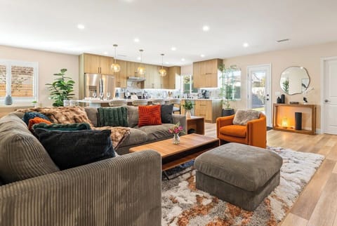 Bright, open-concept living area with a large kitchen, breakfast bar, and comfortable sofa.