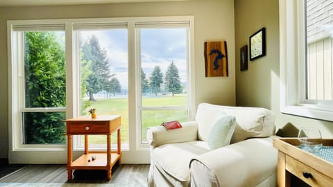 Light filled living Room looking out over lawn, sports court and lake.