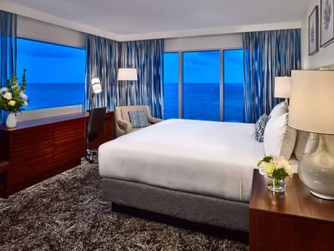Unwind in a serene king bed with sweeping sea views.