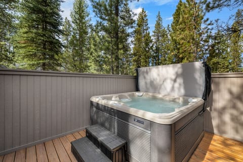 Slip into your private hot tub surrounded by towering pines, where warm bubbling water meets forest tranquility on this secluded deck.