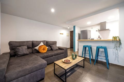 Relax in this modern open-plan living area featuring a plush sectional sofa and a convenient breakfast bar.