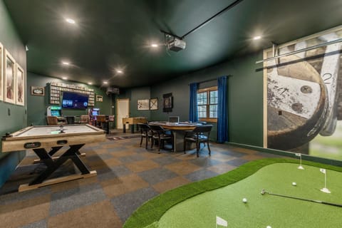 Check out this garage made game room.  Equipped with air hockey, 6-person poker table, putting green, arcade games, dartboard, foose ball and two smart TVs.