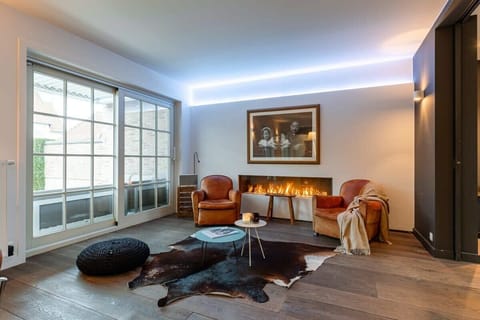 Modern living room with leather armchairs and a sleek fireplace for cozy relaxation.